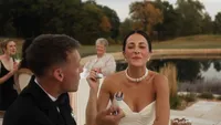 Wedding videography still of couple together during reception with guests around them