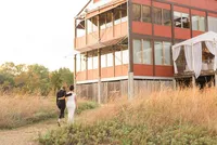 Two brides walk arm in arm in front of the Philip Merrill Environmental Center
