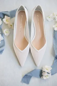 White Stuart Weitzman bridal heels styled with dusty blue ribbon and flowers