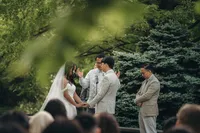 A bride and groom hold hands during their wedding ceremony at Briar Barns in Michigan.