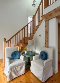 Staircase and pair of blue accent chairs at Brookside Retreat