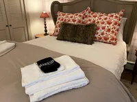 Basement bedroom with guest towels arranged on the bed at Brookside Retreat