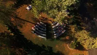 Wedding videography still of overhead shot of wooded ceremony or reception space