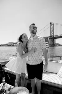 Couple embracing with a bridge in the background during their engagement session