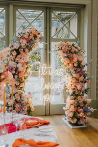 pink wedding floral arch with neon lighting that says 'it was always you'
