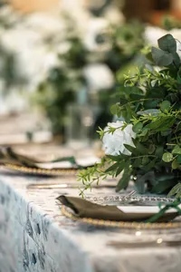close up of White flowers on a wedding reception table with table settings