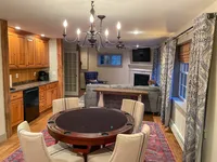 Den with game table, kitchen and fireplace at Brookside Retreat