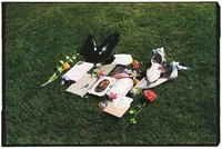 Flat lay film wedding photo of wedding stationary, the bride and groom's shoes, their rings, and a few florals.