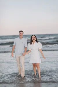 Couple walking along the shoreline during their engagement session