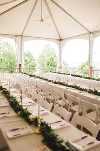 A white tented indoor-outdoor wedding reception with long tables at Chesapeake Bay Foundation Weddings and Events