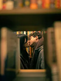 Grand Rapids couples photographer Grace Wan captures a man and woman kissing through a bookshelf.