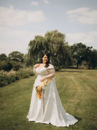 A bride poses for a portrait on her wedding day outside during summer in Michigan.