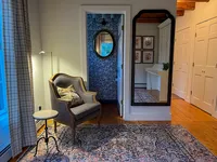 Reading chair, side table and mirror in the Brookside Retreat office