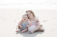Young siblings sitting together on the beach