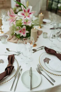 Wedding table styled with pink floral centrepiece and chocolate napkins