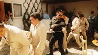 Wedding videography still of guests gathered inside celebrating and enjoying reception