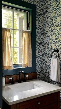 Powder room vanity with blue patterned wallpaper at Brookside Retreat