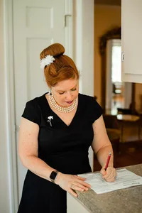Officiant with Weddings & Events by Raina signs the marriage license