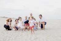 Extended family group kneeling together on the beach