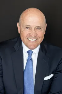 Corporate headshot of a man in a navy suit