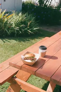 Breakfast sandwich and coffee on outside seating bench