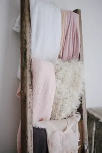 Fabric wraps and swaddles displayed on a styling ladder at the cottage studio