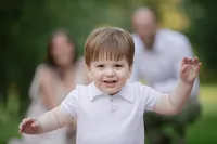 Toddler boy smiling during his outdoor family portrait session