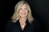 Professional headshot of a woman against a dark background
