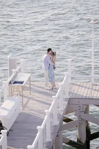 Couple standing on a dock during their waterfront engagement session