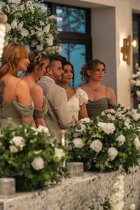 bride groom and bridesmaids surrounded by white wedding florals