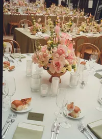 reception table with pink florals - Photograph of elegant reception dining table with pink and coral flower centerpiece, white place settings, and candlelight
