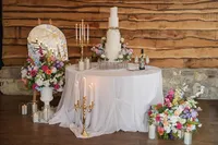 colourful floral wedding styling around table with candles and a wedding cake