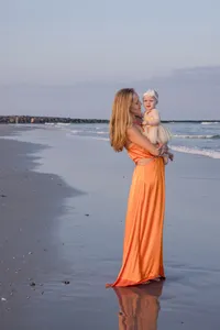 Mother embracing her toddler during a beach portrait session