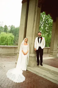 bride and groom at columned portico - Photograph of couple standing together under white classical columns in formal architectural setting