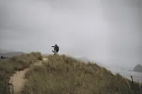 A man holds up and spins his fiancé during their destination engagement photography session with Grace Wan.