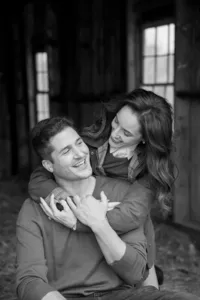 Couple laughing during an embrace, photographed in black and white