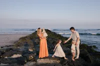 Family walking together along the shoreline during their beach portrait session