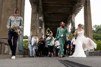 couple-guests-walking-brass-band-12th-street-bridge-wedding