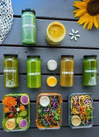 Colorful spread of fresh juice, salads, and dressings by The Country Eatery