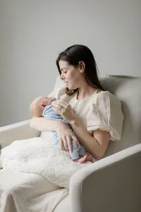 Mother seated in a chair holding her newborn baby