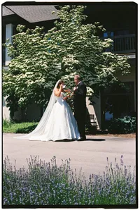 A bride cries while showing her dad her dress for the first time, by film wedding photographer Grace Wan.