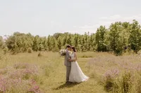 A bride and groom take portraits on the green, wooded Bayfront landscape at Chesapeake Bay Foundation Weddings and Events