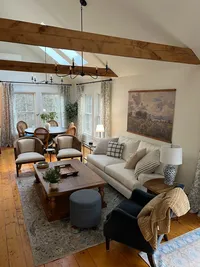 Open living room with exposed beams and comfortable seating at Brookside Retreat