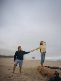 Destination couples photographer Grace Wan captures a couple touching hands on Cannon Beach, Oregon.