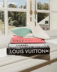 Wedding detail of Vogue, Chanel and Louis Vuitton coffee-table books with a shell dish by a sunny window