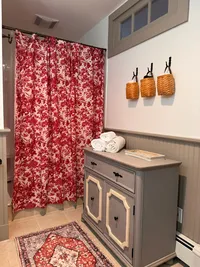 Basement bathroom with red patterned shower curtain and vanity at Brookside Retreat