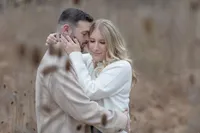 Couple embracing outdoors in soft autumn light during their engagement session