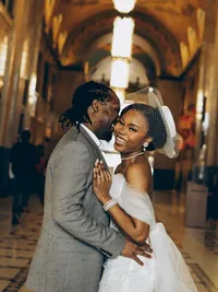 Michigan wedding photographer Grace Wan captures a groom and bride standing face to face inside of the state capitol building.