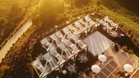 Wedding videography still overhead view of luxury outdoor ceremony with white chairs arranged in rows on grounds