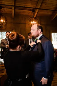 Wedding planner with Weddings & Events by Raina pins on the groom's boutonniere